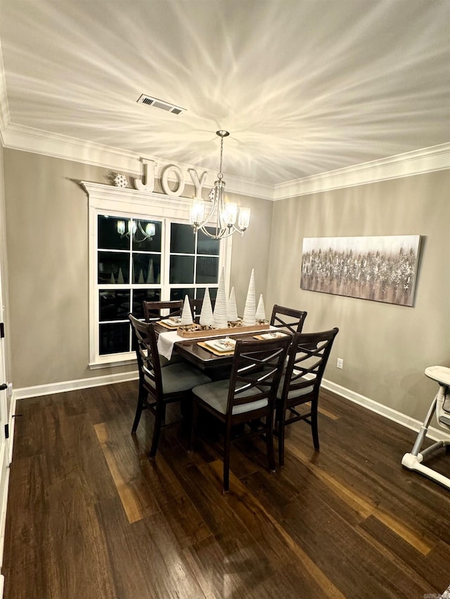 dining room with dark wood-type flooring, ornamental molding, and a chandelier