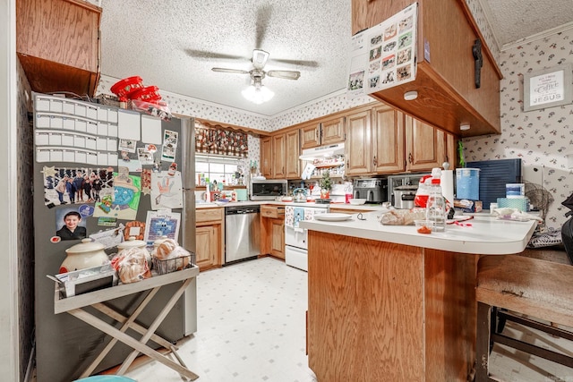 kitchen with ceiling fan, ornamental molding, a textured ceiling, kitchen peninsula, and stainless steel appliances