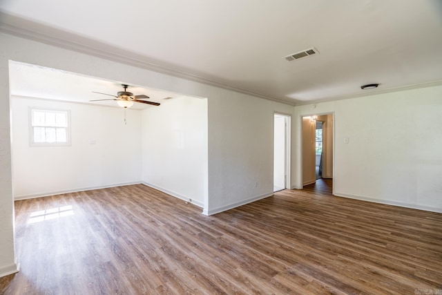 spare room featuring dark hardwood / wood-style floors, ceiling fan, and crown molding