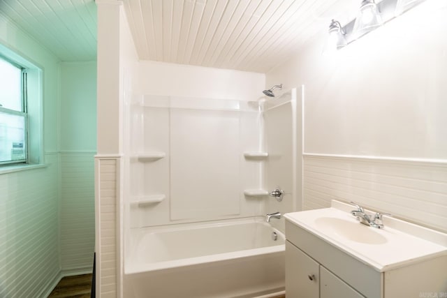 bathroom featuring vanity, shower / bathtub combination, and tile walls