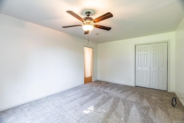 unfurnished bedroom featuring carpet flooring, ceiling fan, and a closet