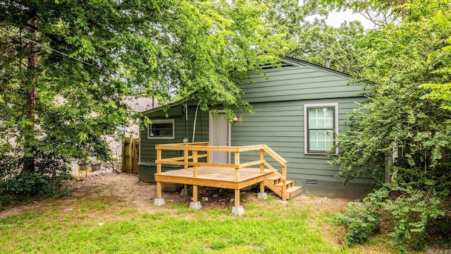 rear view of property with a yard and a wooden deck