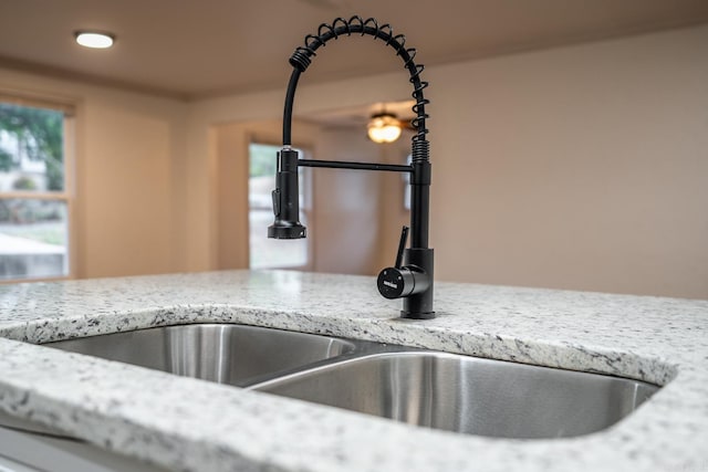 details featuring light stone counters and sink