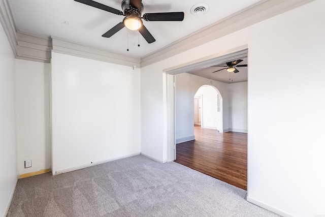 spare room featuring hardwood / wood-style floors, ceiling fan, and crown molding