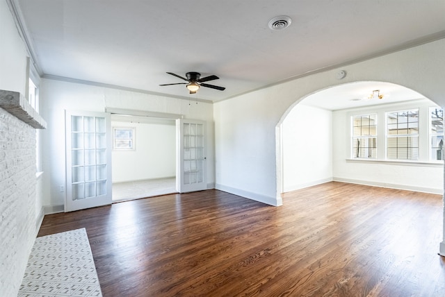 empty room featuring dark hardwood / wood-style floors, ceiling fan, ornamental molding, and french doors