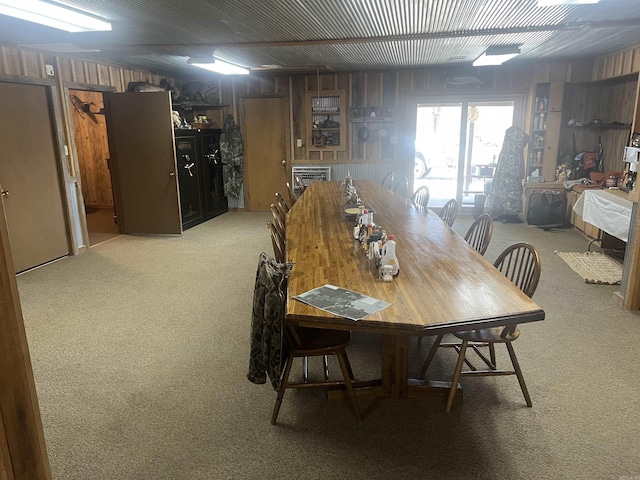 dining area featuring wood walls and carpet floors