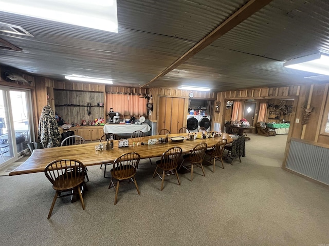 dining space with carpet, separate washer and dryer, and wooden walls