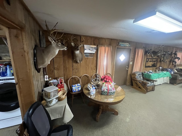 basement with carpet flooring, wood walls, and washer / clothes dryer