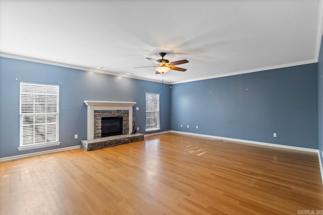 unfurnished living room featuring a fireplace, light wood-type flooring, ceiling fan, and crown molding