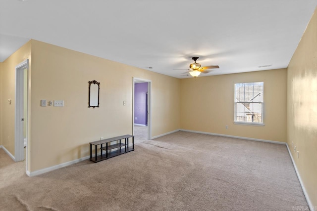 carpeted spare room featuring ceiling fan