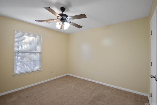 carpeted spare room featuring ceiling fan