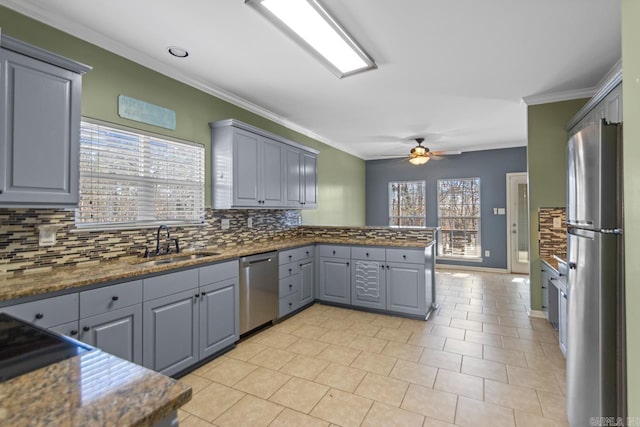 kitchen with ceiling fan, sink, gray cabinets, appliances with stainless steel finishes, and ornamental molding