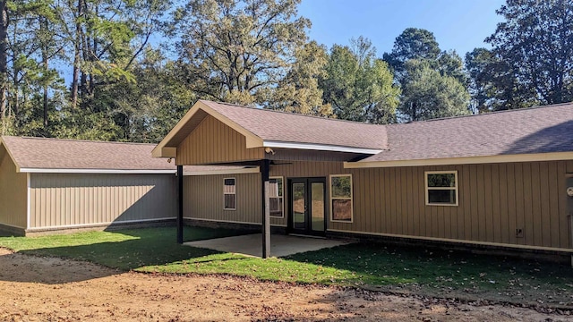 back of house with a yard and a patio