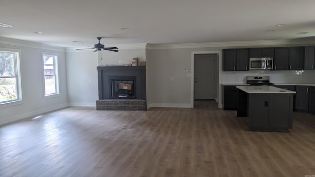 kitchen featuring a fireplace, range, a center island, and dark hardwood / wood-style flooring