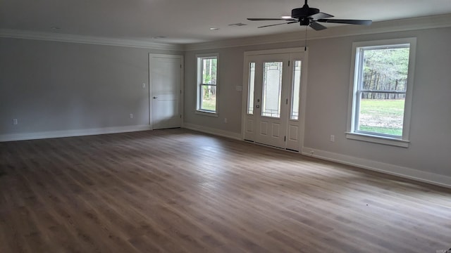 empty room featuring plenty of natural light, dark hardwood / wood-style floors, crown molding, and ceiling fan