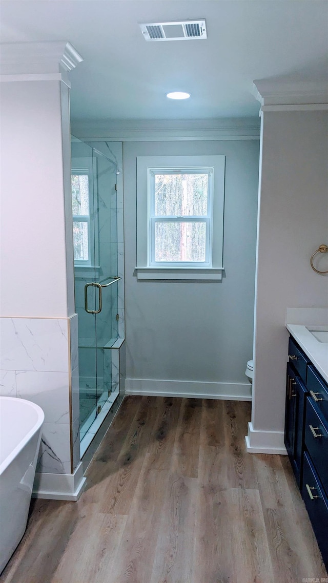 full bathroom featuring vanity, separate shower and tub, wood-type flooring, and ornamental molding