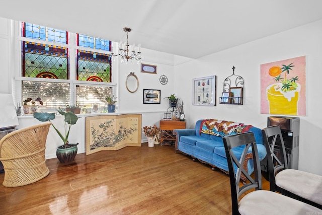 sitting room with hardwood / wood-style floors and an inviting chandelier