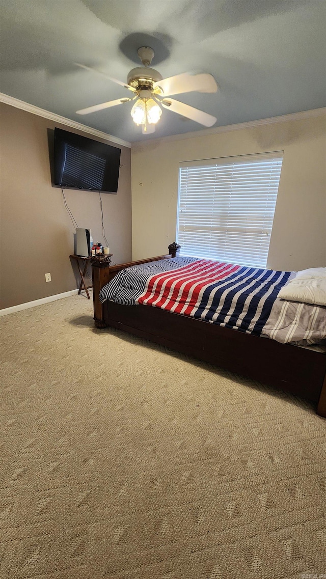 carpeted bedroom with ceiling fan and ornamental molding