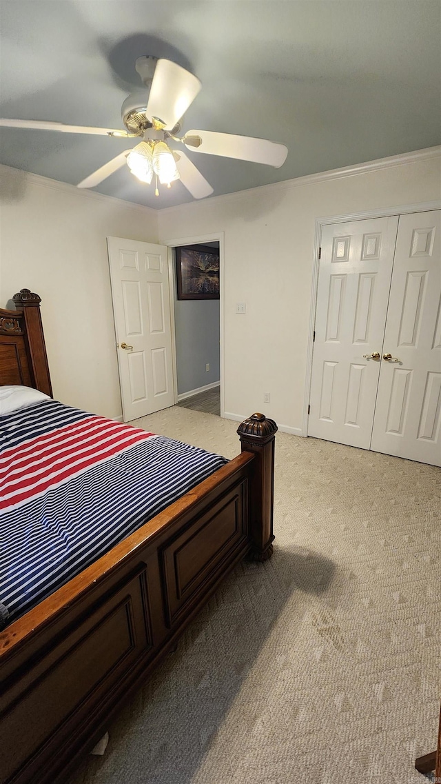 bedroom with ceiling fan, light carpet, and a closet