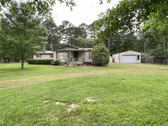 view of yard featuring covered porch, a garage, and an outbuilding