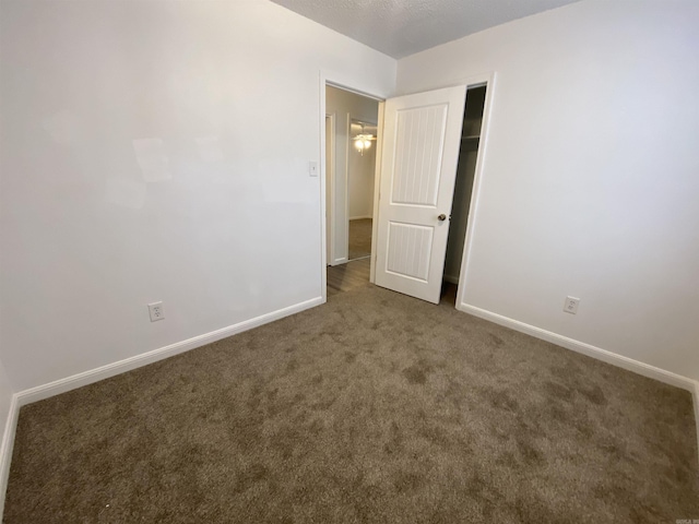 unfurnished bedroom with dark carpet