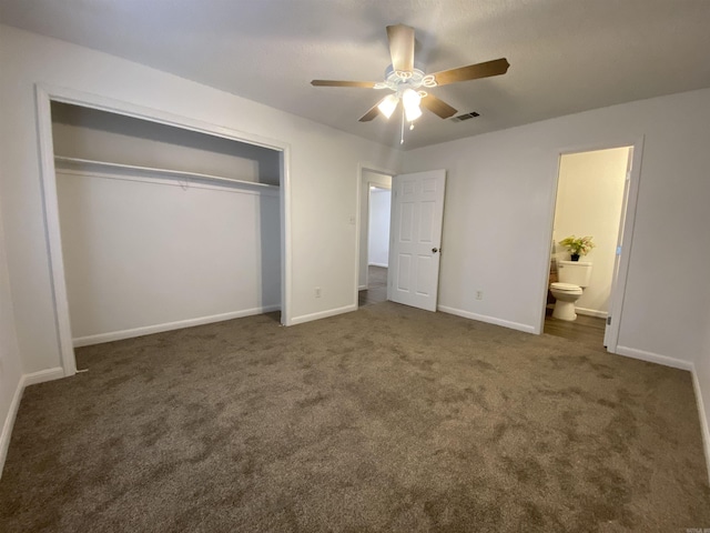 unfurnished bedroom featuring dark colored carpet, ceiling fan, connected bathroom, and a closet