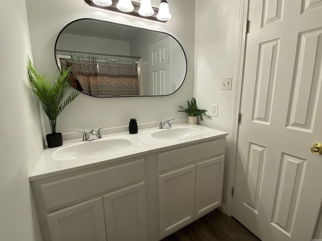 bathroom with hardwood / wood-style floors, vanity, and curtained shower