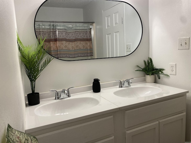 bathroom featuring vanity, curtained shower, and a textured ceiling