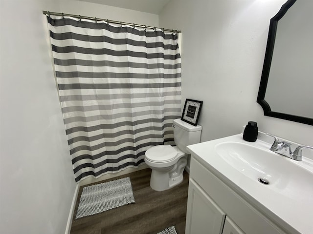 bathroom featuring wood-type flooring, vanity, toilet, and walk in shower