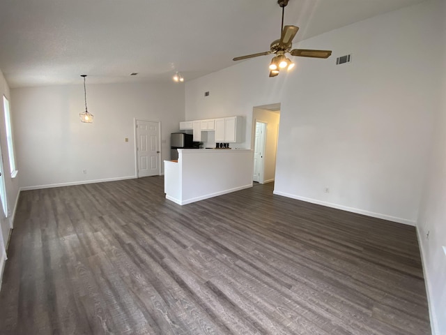 unfurnished living room with ceiling fan, dark hardwood / wood-style flooring, and high vaulted ceiling