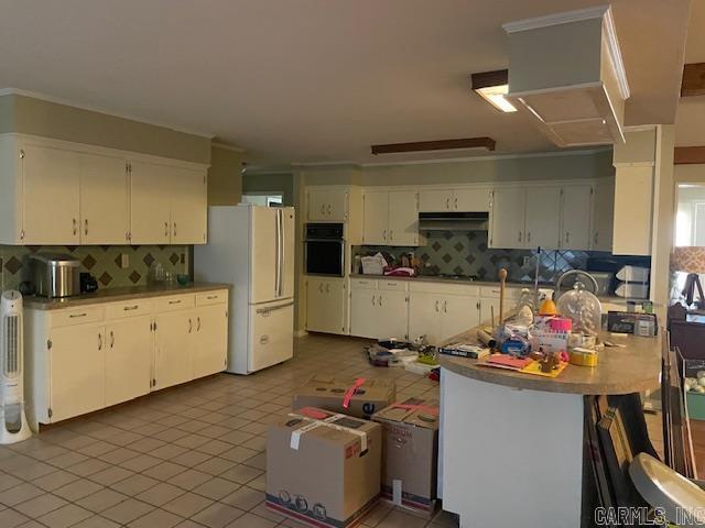 kitchen with white cabinetry, oven, white fridge, and tasteful backsplash