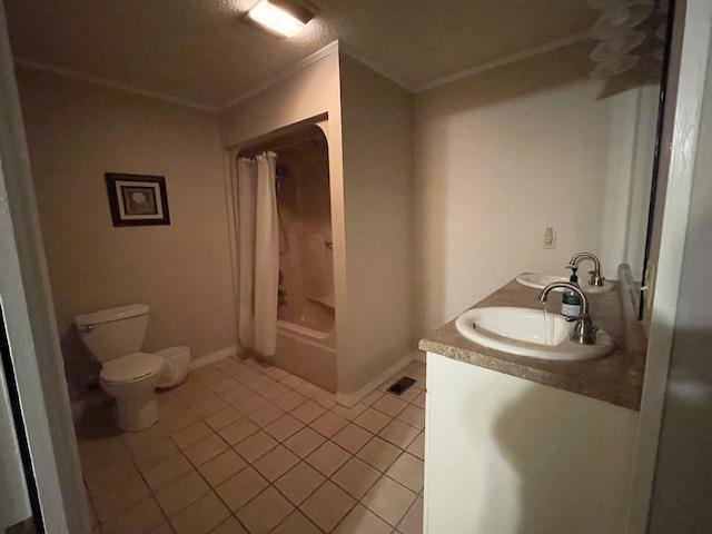 full bathroom featuring tile patterned flooring, toilet, a textured ceiling, shower / bath combination with curtain, and vanity