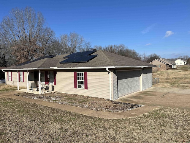 ranch-style home featuring solar panels, a garage, and a front lawn