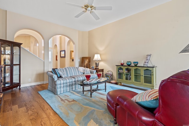 living room with ceiling fan and dark hardwood / wood-style flooring