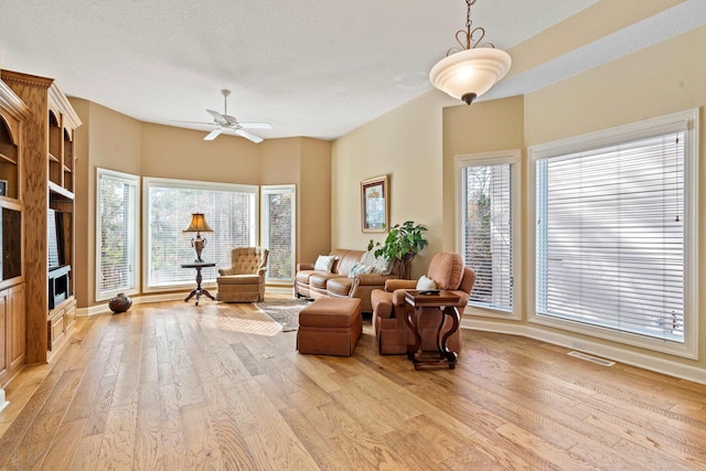 sitting room with a textured ceiling, light hardwood / wood-style floors, and ceiling fan