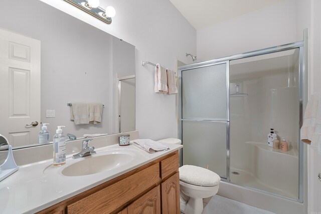 bathroom featuring vanity, toilet, and an enclosed shower