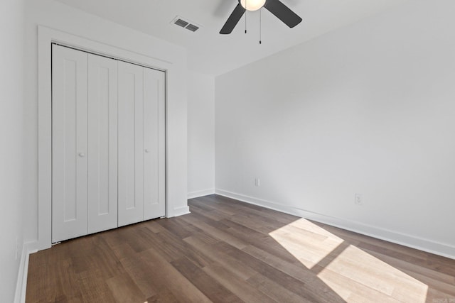 unfurnished bedroom featuring dark hardwood / wood-style flooring, a closet, and ceiling fan