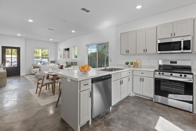 kitchen with sink, white cabinetry, kitchen peninsula, and appliances with stainless steel finishes