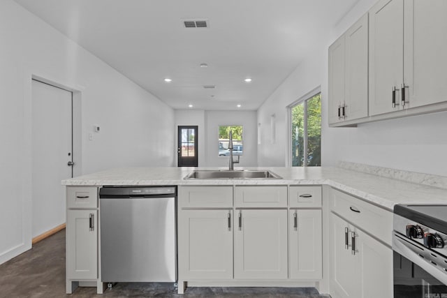 kitchen with sink, stainless steel appliances, white cabinets, and kitchen peninsula