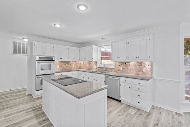 kitchen featuring white cabinetry, sink, a center island, and stainless steel appliances