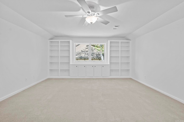 interior space with built in shelves, light carpet, ceiling fan, and lofted ceiling