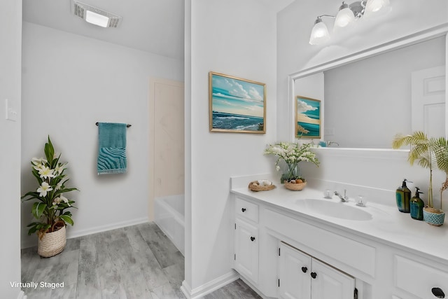 bathroom featuring hardwood / wood-style floors, vanity, and shower / bathing tub combination