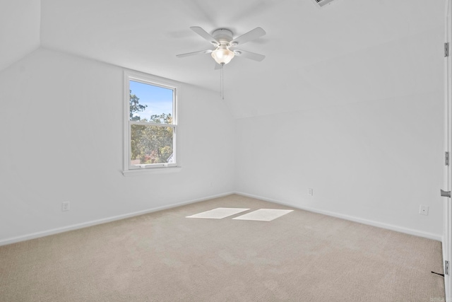 additional living space with ceiling fan, light colored carpet, and vaulted ceiling