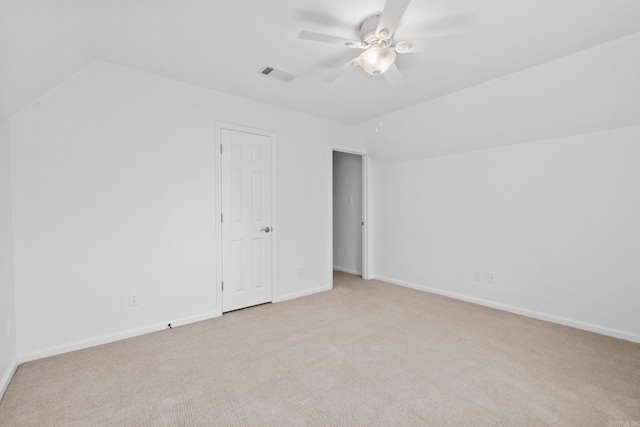 empty room featuring ceiling fan, light colored carpet, and vaulted ceiling