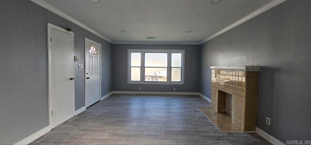 unfurnished living room featuring a fireplace, wood-type flooring, and crown molding