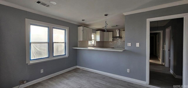 kitchen featuring white cabinetry, wall chimney range hood, tasteful backsplash, kitchen peninsula, and light wood-type flooring