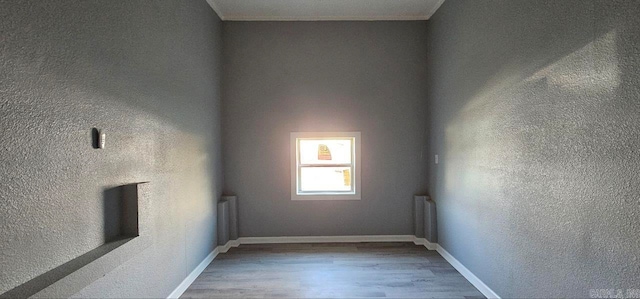 empty room with radiator heating unit and wood-type flooring