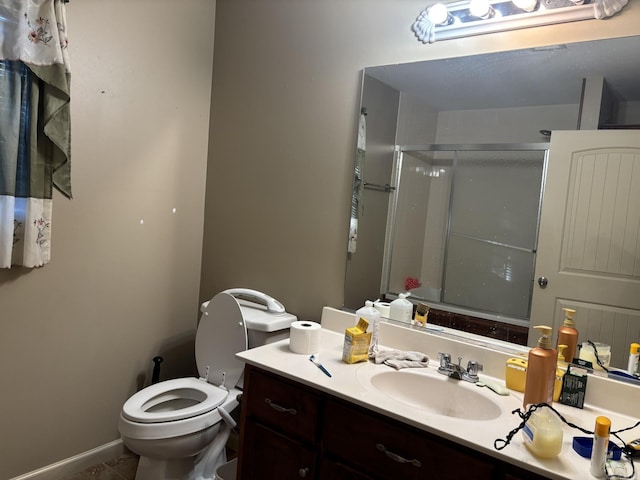 bathroom with tile patterned flooring, vanity, toilet, and a shower with door