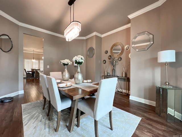 dining room with dark hardwood / wood-style floors, crown molding, and a chandelier