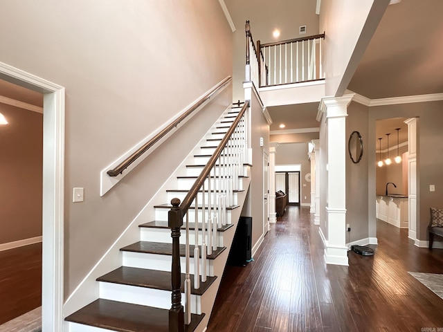 stairway with hardwood / wood-style flooring, ornamental molding, and sink